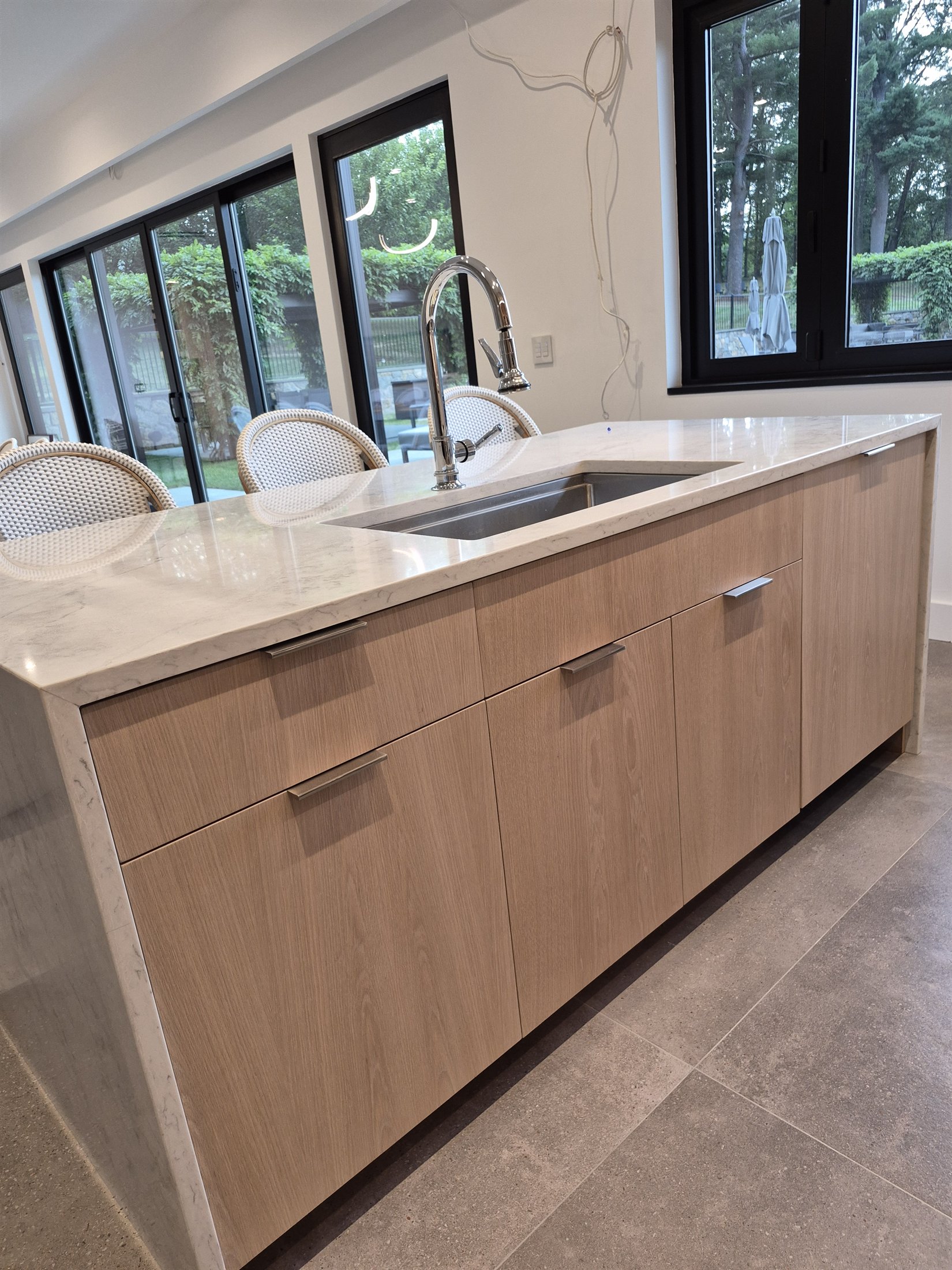 Close view of a white-oak island with integrated doors and drawers